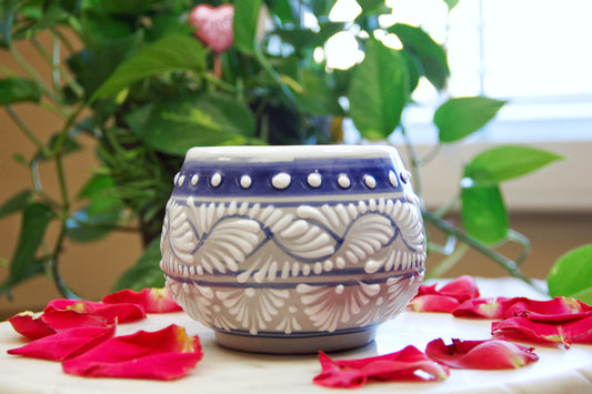 Side view of the artisanal candle. Blue Grey color with white hand painted design. Handcrafted by Artisan in Puebla, Mexico. 100% All Natural Soy Candle. Reuse the talavera as home decor or storage.