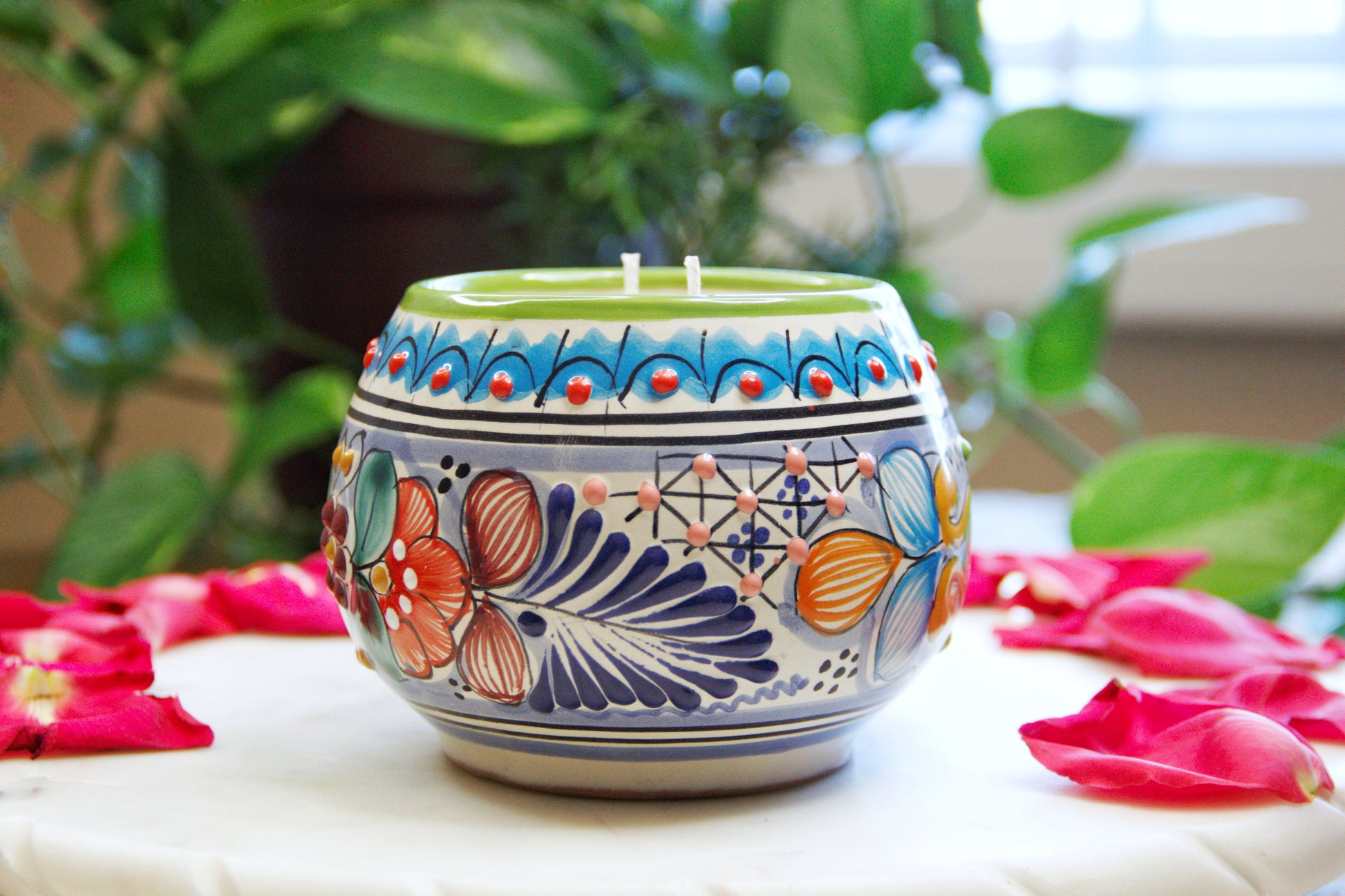 side view of  an Artisanal candle in a beautiful multicolored talavera cup with a handle. Handcrafted by Artisan in Puebla, Mexico. 100% All Natural Soy Candle. Reuse the talavera as home decor or storage.