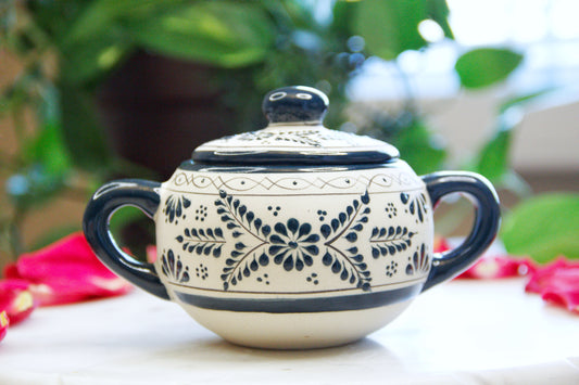 Front view of the handmade artisanal candle in a green floral design talavera with handles on both sides and a closed lid. Custom made by Artisan in Mexico. 100% All Natural Soy Candle. Reuse the talavera as home decor or storage.