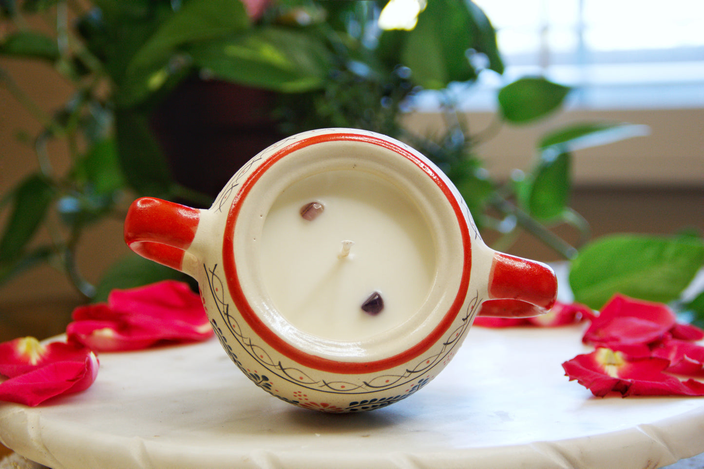 Top view of the handmade artisanal candle in a red floral design talavera with handle on both sides. Custom made by Artisan in Mexico. 100% All Natural Soy Candle. Reuse the talavera as home decor or storage.