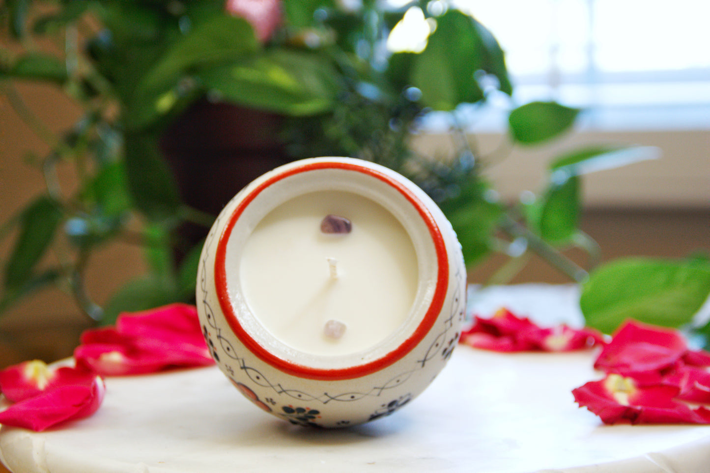 Top view of the handmade artisanal candle in a red floral design talavera. Custom made by Artisan in Mexico. 100% All Natural Soy Candle. Reuse the talavera as home decor or storage.