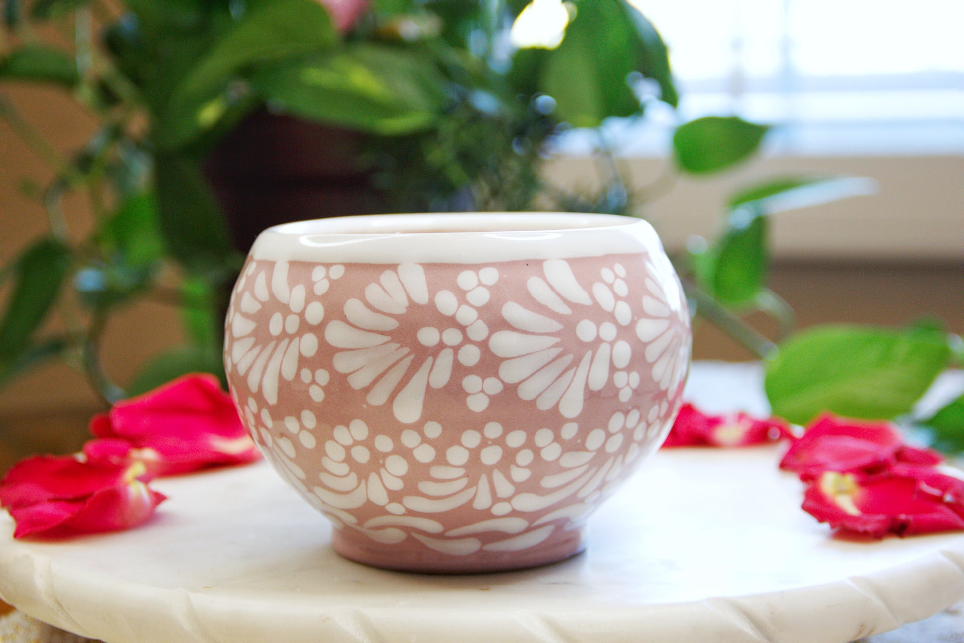 side of an Artisanal candle in a beautiful pink cup with handle, handmade white paint strokes design. Handcrafted by Artisan in Puebla, Mexico. 100% All Natural Soy Candle. Reuse the talavera as home decor or storage.