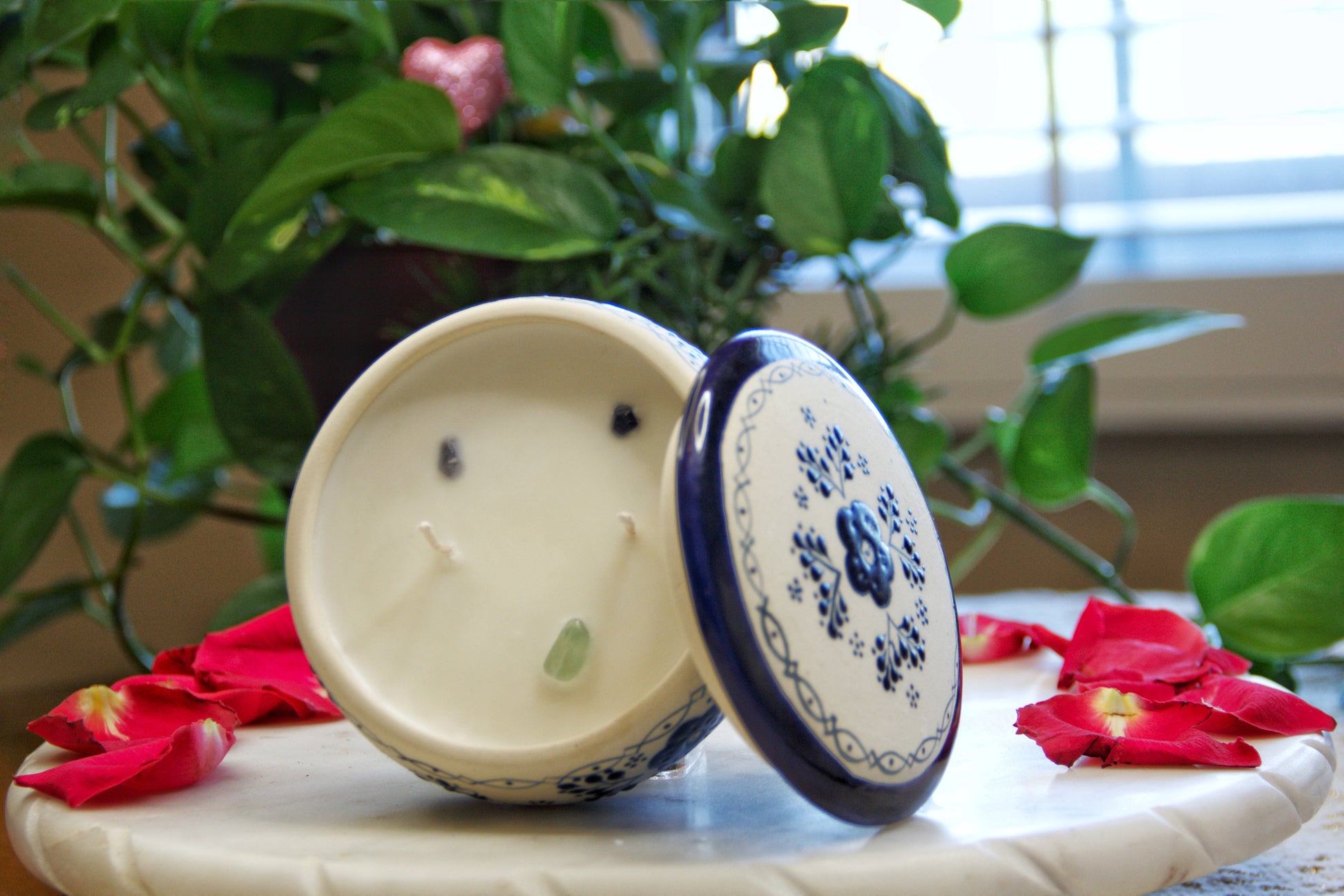 top view of a handmade artisanal candle in a blue floral design talavera with an open lid. Custom made by Artisan in Mexico. 100% All Natural Soy Candle. Reuse the talavera as home decor or storage.
