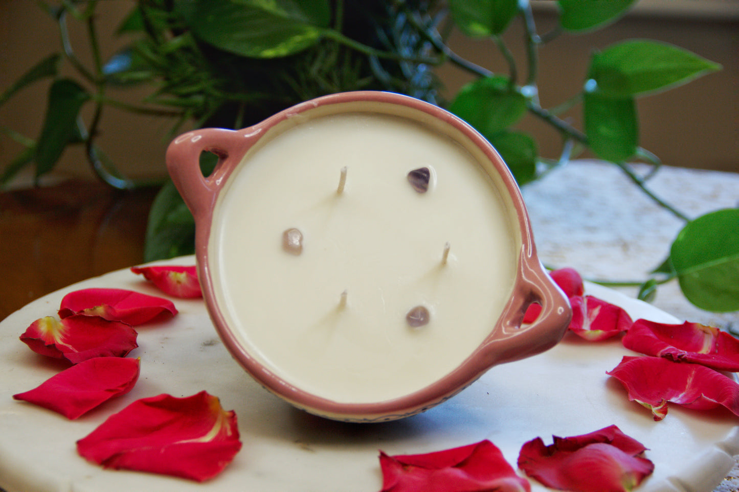 Titled top view of Artisanal candle in a beautiful salsa talavera bowl. Handmade pink floral design. Handcrafted by Artisan in Mexico City. 100% All Natural Soy Candle. Reuse the talavera as home decor or storage.